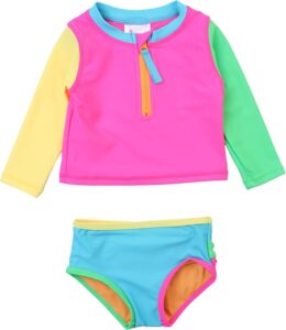 Toddler girl wearing a long sleeve rash guard bikini set with ruffle bottoms for sun protection at the beach or pool