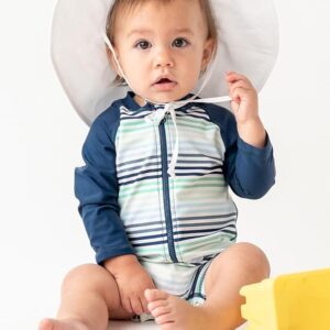 Baby boy wearing a RuggedButts one-piece zipper rash guard sunsuit in Coastal Stripes with UPF 50+ sun protection for beach, pool, and splash pad play Baby boy wearing a RuggedButts one-piece zipper rash guard sunsuit in Coastal Stripes with UPF 50+ sun protection for beach, pool, and splash pad play