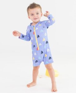 Baby wearing a RuffleButts long sleeve one-piece rash guard swimsuit with UPF 50+ sun protection and front zipper Baby wearing a RuffleButts long sleeve one-piece rash guard swimsuit with UPF 50+ sun protection and front zipper